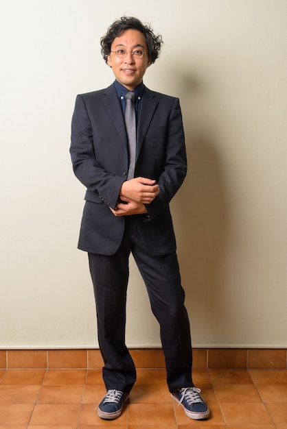 Japanese businessman in suit with curly hair indoors