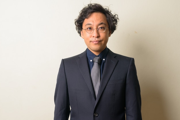 Japanese businessman in suit with curly hair indoors