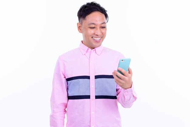 흰 벽에 고립 된 분홍색 셔츠와 함께 일본 사업가