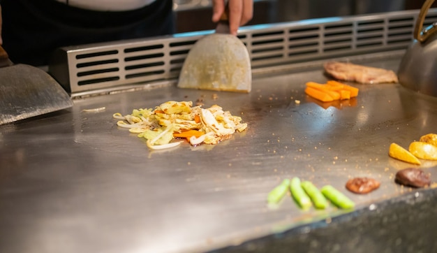 Japanese chef cooking meat in teppanyaki restaurant