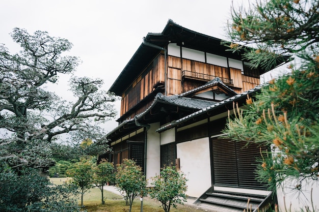 日本の伝統的な伝統的な建物で、美しい庭園が横にある森で構成されています。日本の京都にある 2 階建ての静かな木造住宅。日本のリビングハウススタイル。