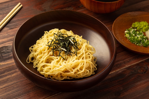 Japanese cold ramen noodles or "Zaru Soba" with chopped green onions, grated wasabi and cup for dipping sauce