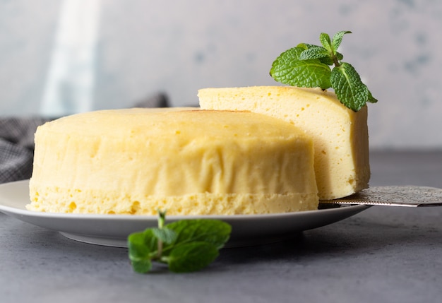 Japanese cotton cheesecake with mint on a grey plate.