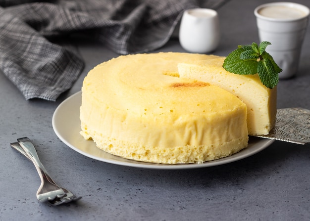 Japanese cotton cheesecake with mint on a grey plate.