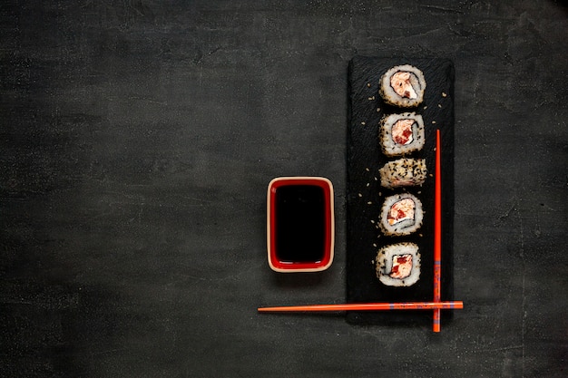 Фото Суши из мусса из японского краба с соевым соусом на каменной доске с палочками для еды