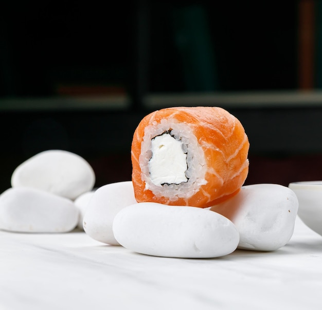 Фото Ролл филадельфия японской кухни с лососем на белом столе