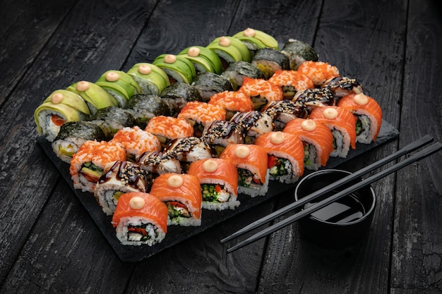 Japanese cuisine Rolls with salmon tuna on a black table