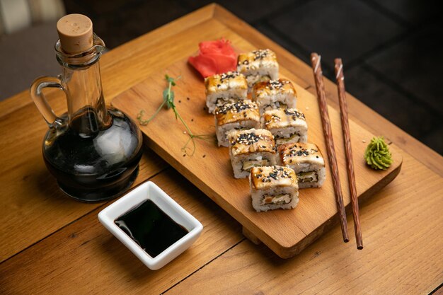 Japanese cuisine Rolls with sauce on a wooden plate