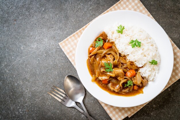 Riso al curry giapponese con fette di maiale, carote e cipolle