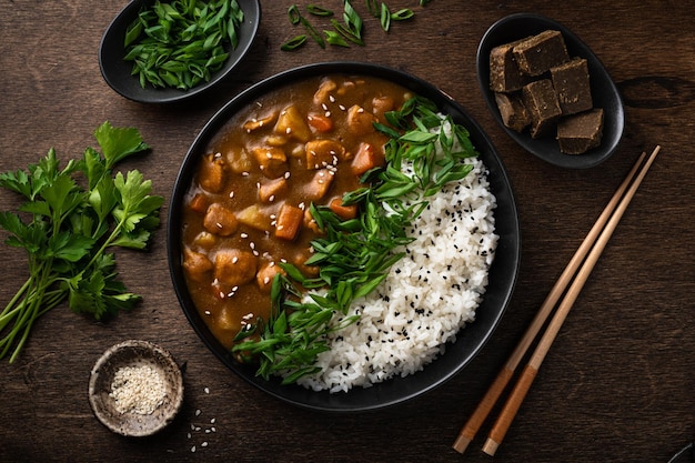 Japanese curry with rice in a black ceramic plate view from above