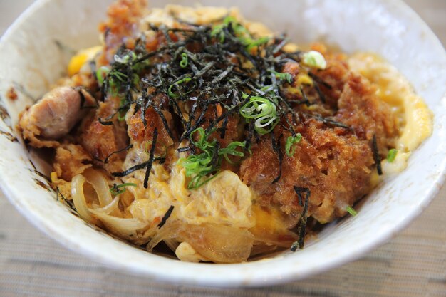 日本の揚げ豚肉、ご飯に卵、木の背景にカツ丼