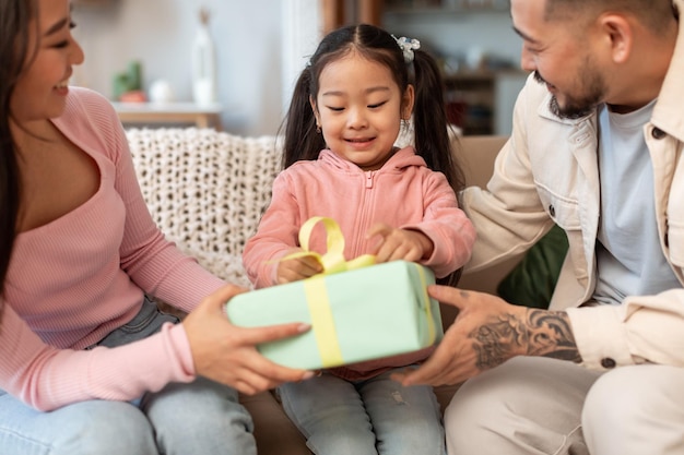 Japanese family celebrating baby daughters birthday giving gift at home