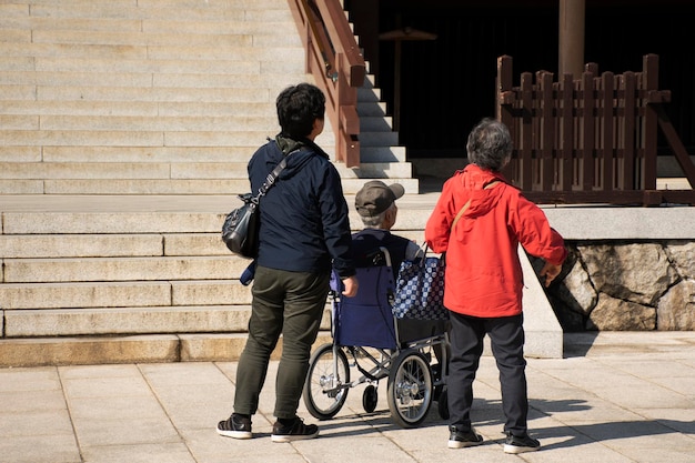 사진 2019년 3월 31일 일본 도쿄에서 지바현 나리타산 신쇼지 사원을 방문하고 기도하는 노인 아버지를 데리고 휠체어를 밀고 가는 일본인 가족