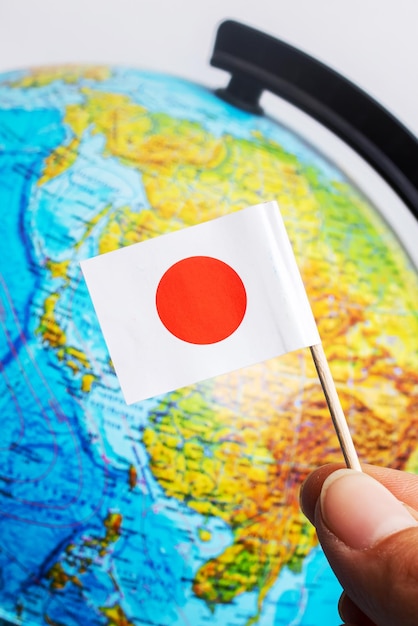 Japanese flag on background of globe with map