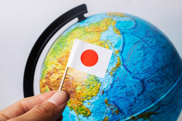 Japanese flag on background of globe with map