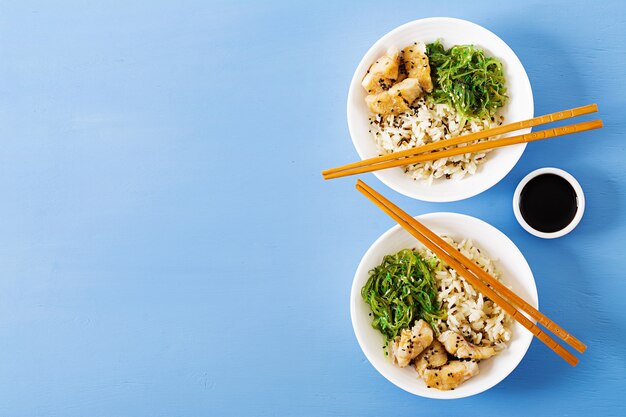 Japanese food. Bowl of rice, boiled white fish and wakame chuka or seaweed salad. 