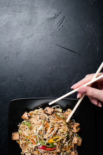Японская культура питания. женщина, использующая палочки для еды в качестве традиционных столовых приборов