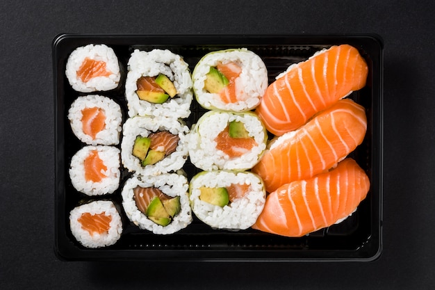 japanese food: maki and nigiri sushi set on black