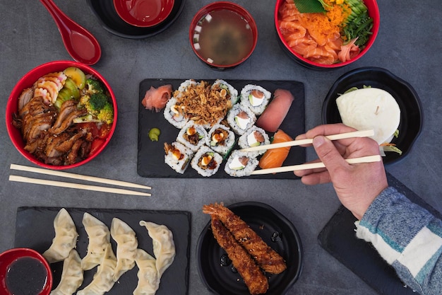 japanese food restaurant assorted sushi platter close up of hand with rolling chopsticks