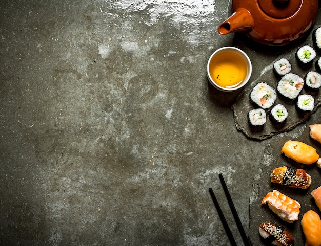 Japanese food Sushi rolls and a Cup of tea on the stone table