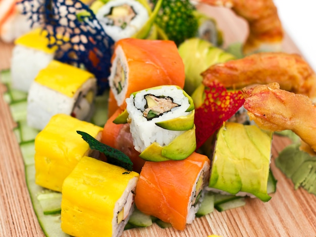 Japanese food - Sushi, sashimi, rolls on a wooden board. Isolated