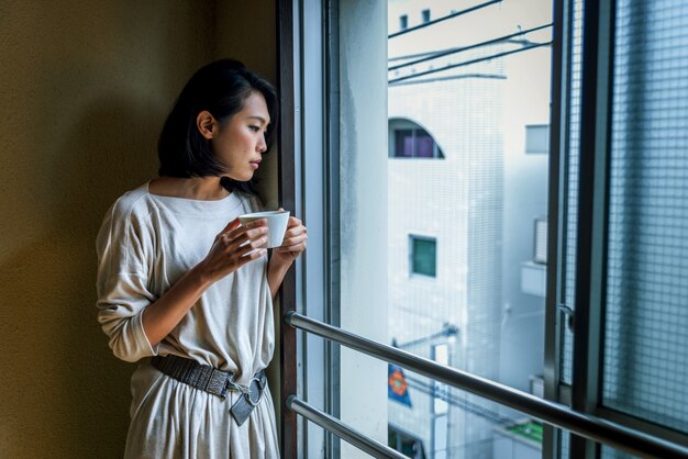 Japanese girl sits at home and drinks tea