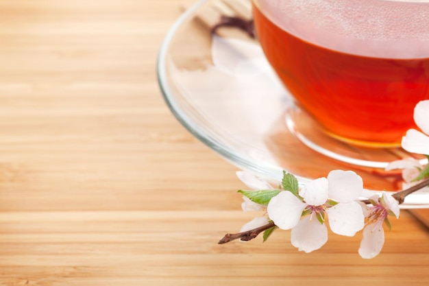 Japanese green tea and sakura branch over mat and bamboo table