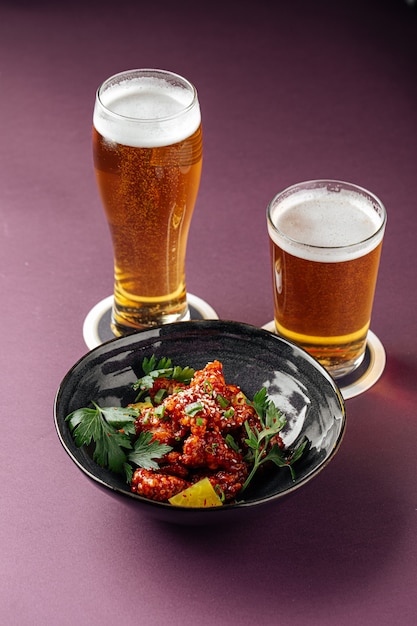 Japanese karaage chicken with beer on a purple