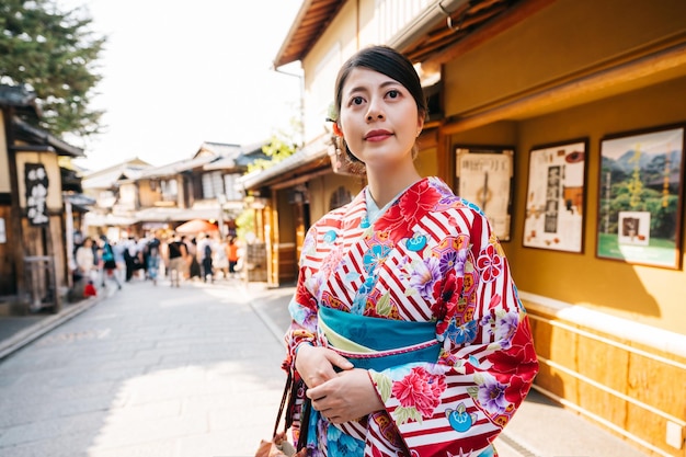 旧市街の通りで友達が一緒に祭りに行くのを待っている日本の女性。伝統的な日本の少女のライフ スタイル。京都の着物姿の美女。