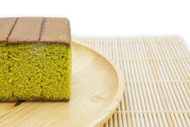 Japanese Matcha green tea cake cheesecake on wooden plate and traditional mat 