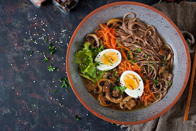 Japanese miso ramen noodles with eggs, carrot and mushrooms. Soup delicious food. Flat lay. Top view