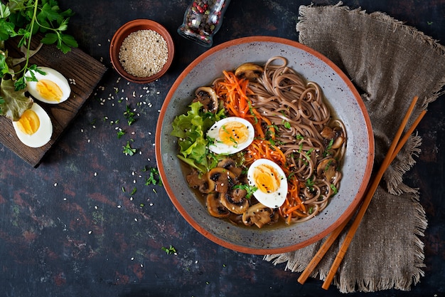 Japanese miso ramen noodles with eggs, carrot and mushrooms. Soup delicious food. Flat lay. Top view