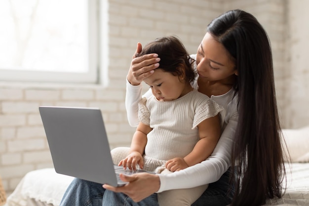 Japanese mom and baby having online medical appointment at home