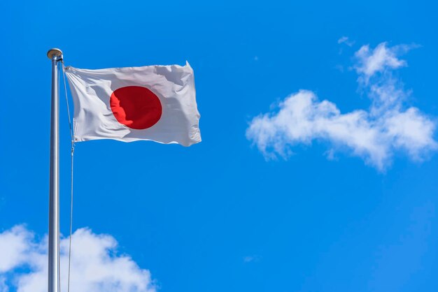 Japanese national flag waving in the wind against a sunny blue sky