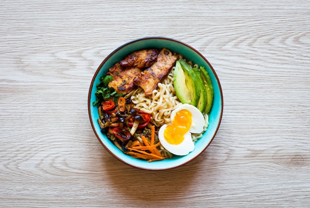 Japanese noodles bowl with chicken,  carrots,  avocado