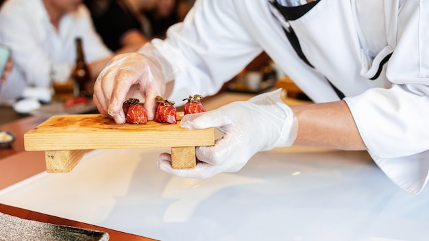 Photo japanese omakase meal aging raw akami tuna sushi adds with sliced truffle served by hand.