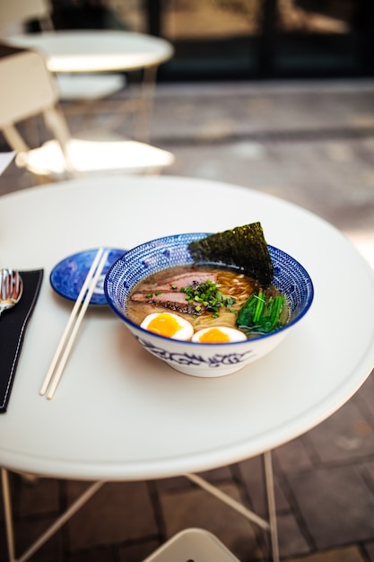 Japanese ramen noodle soup on the table in outdoor cafe terrace