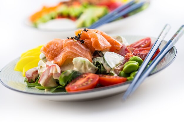 Japanese salad with fish salmon and vegetable and chopsticks.