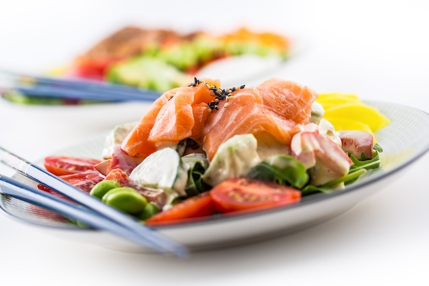 Japanese salad with fish salmon and vegetable and chopsticks.