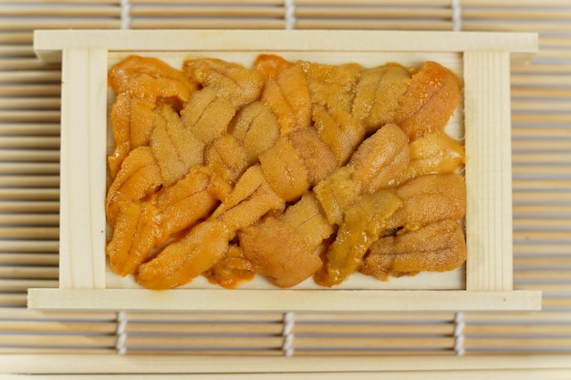 Japanese sea urchin in wooden tray , sushi and sashimi ingredients