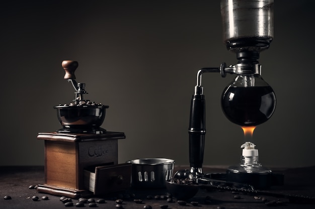 Japanese siphon coffee maker and coffee grinder on old kitchen table