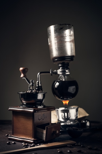 Japanese siphon coffee maker and coffee grinder on old kitchen table