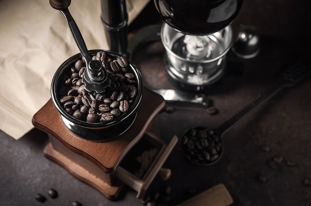 Japanese siphon coffee maker and coffee grinder on old kitchen table