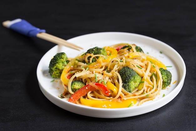 Japanese Stir fry udon noodles with vegetables on the black table, cooked in wok