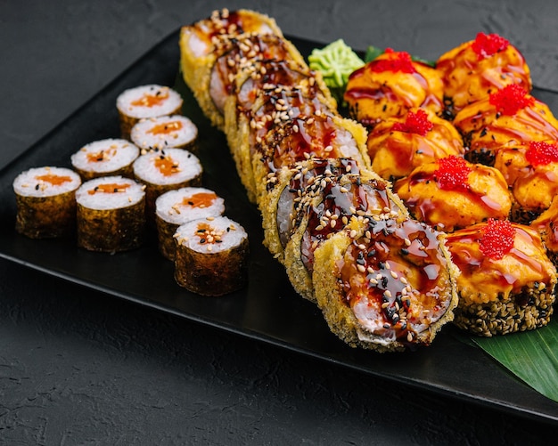 Фото Ассорти из японских суши на черной каменной тарелке