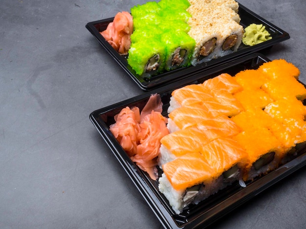 Japanese sushi on a dark background Sushi rolls pickled ginger wasabi Sushi set on a table