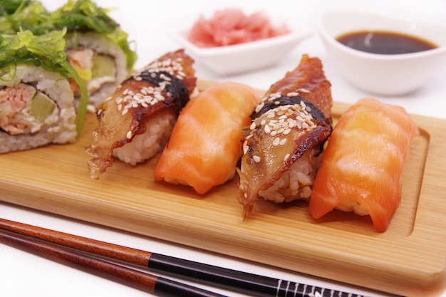 生姜、醤油、海苔サラダを添えた木製トレイの日本寿司
