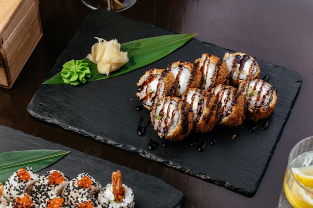 Japanese sushi rolls on a black stone plate