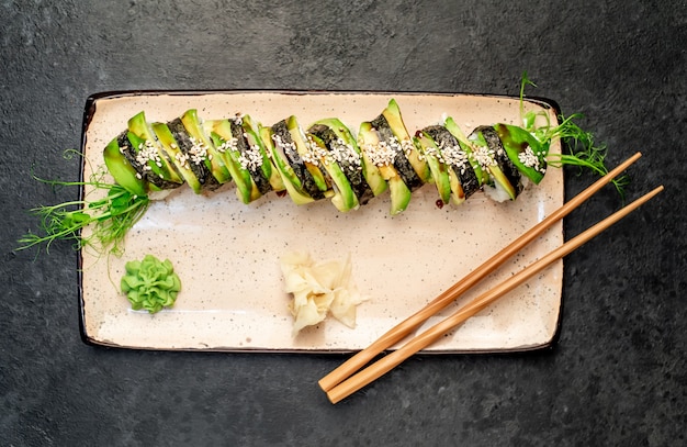 Japanese sushi rolls green dragon on a stone background ready\
to eat