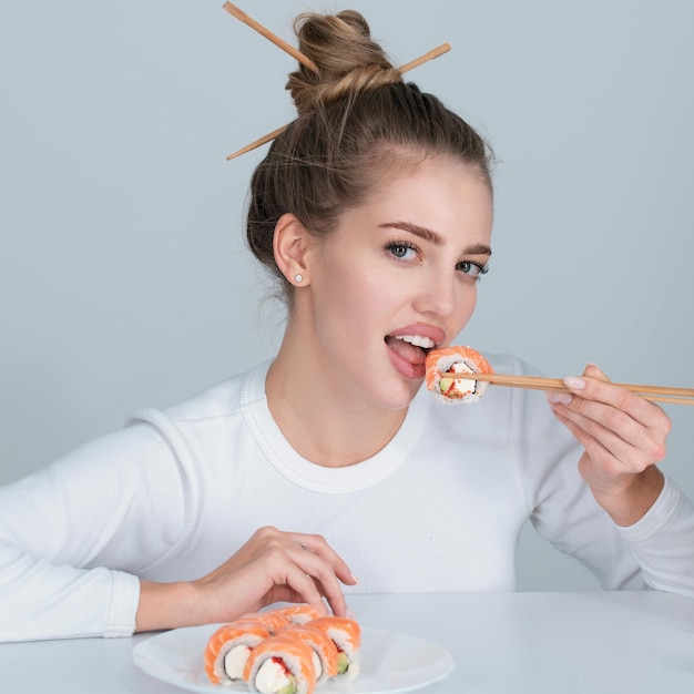 Japanese sushi style sexy woman eat japanese traditional food sushi rolls girl is holding japanese s